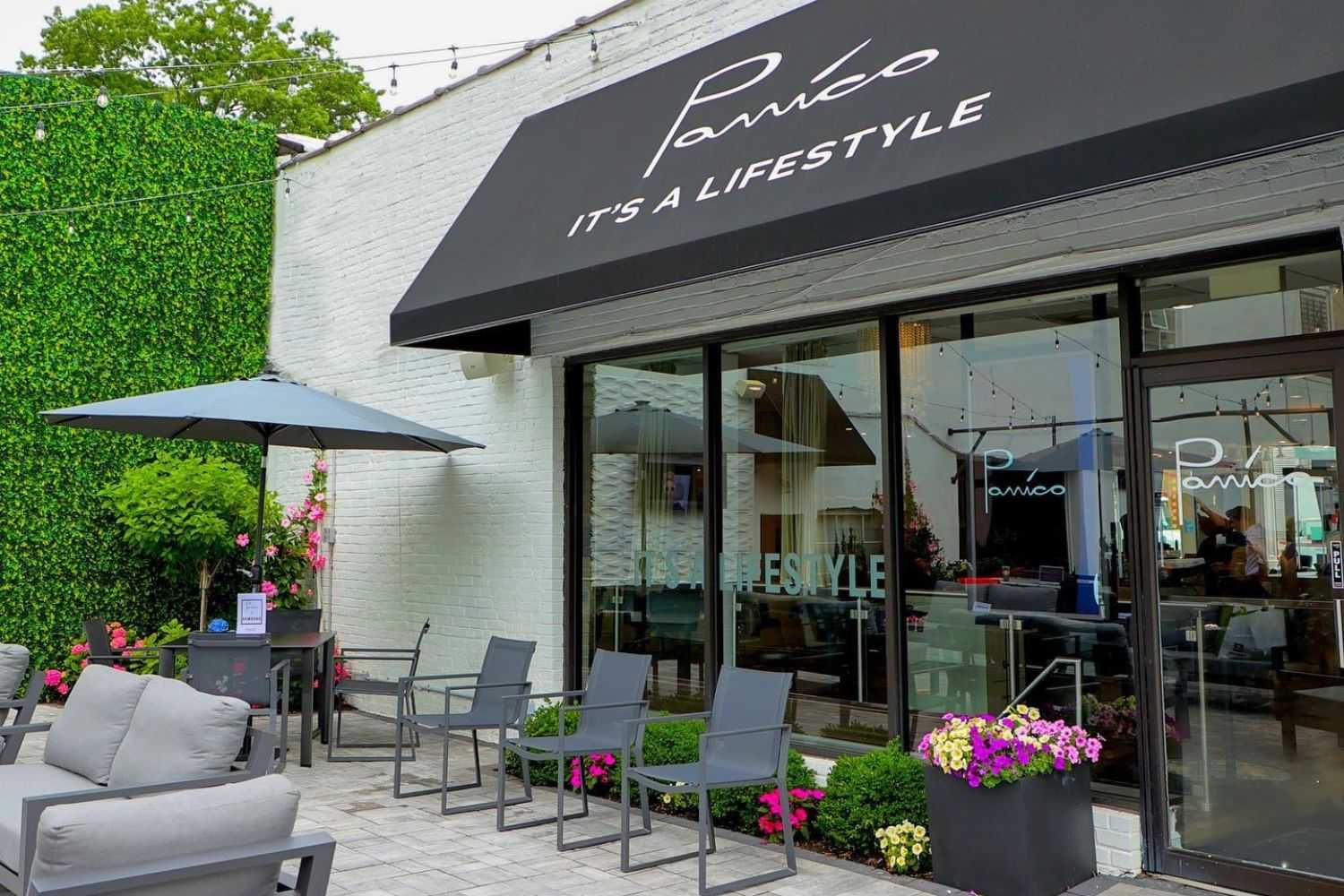 Chic outdoor cafe with seating, floral decor, and a stylish canopy.